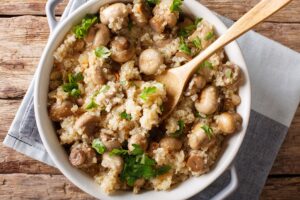 Quinoa cu ciuperci, usturoi și pătrunjel în bol cu lingură