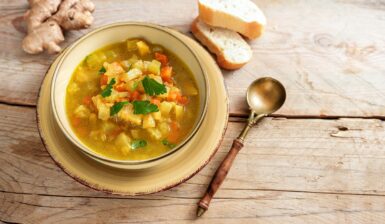 Supă de cartofi cu țelină apio și ghimbir în bol, o lingură, două felii de pâine și ghimbir