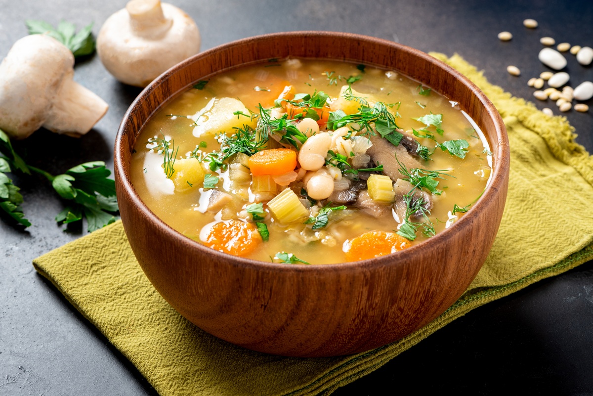 Supă rustică cu ciuperci și fasole albă în bol alb