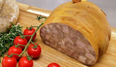 Tobă de casă secționată pe un tocător și o crenguță de roșii cherry