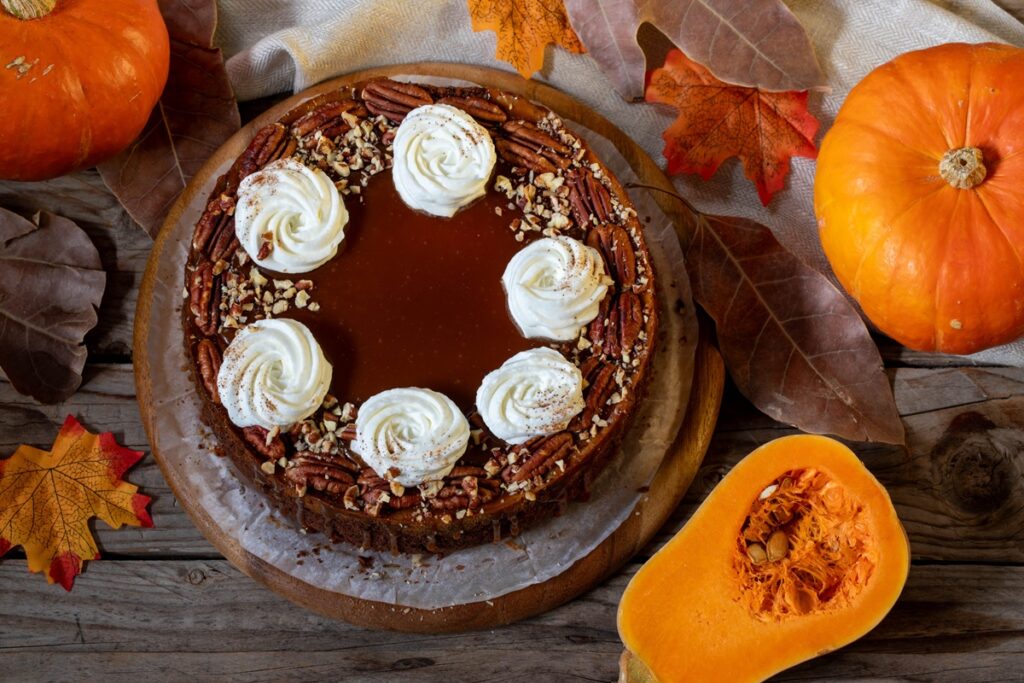 Cheesecake cu dovleac și sos caramel, decorat cu nuci pecan și frișcă