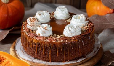 Cheesecake cu dovleac și sos caramel, decorat cu nuci pecan și frișcă