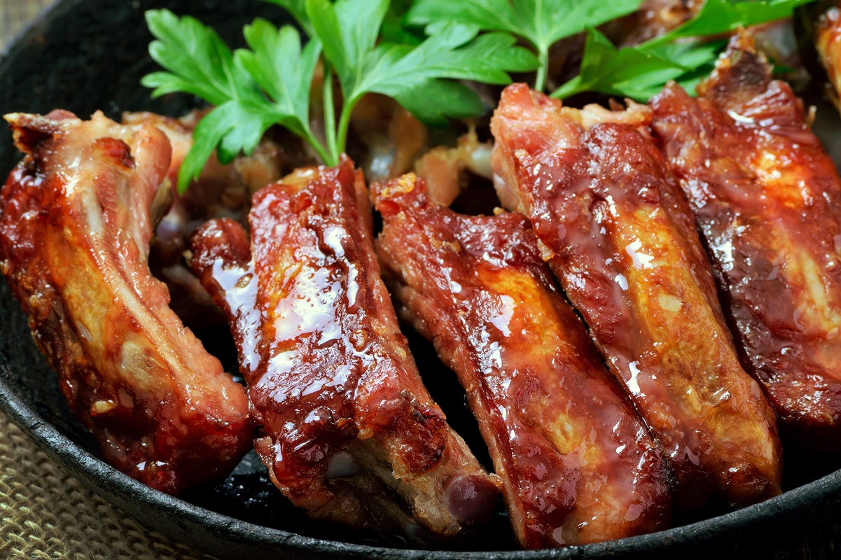 Coaste de porc preparate în untură la tigaie, decorate cu pătrunjel verde