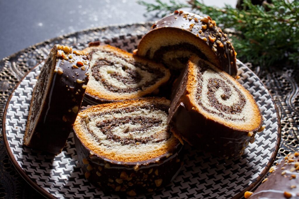 Porții de ruladă cu nucă și cacao glazurată cu ciocolată