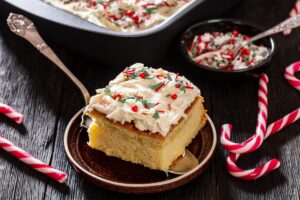 Porție de pandișpan vanilat cu cremă și ornamente pe o spatulă