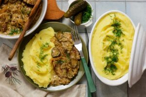 Friptură în sos cu varză călită, piure de cartofi și castraveți acri