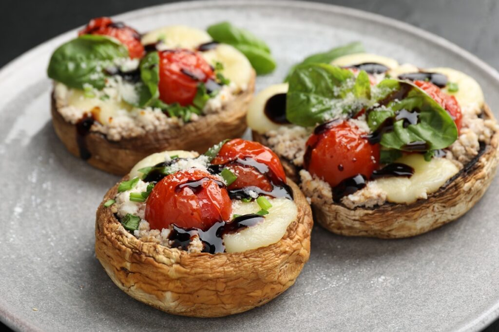 Trei ciuperci umplute cu brânză, roșii cherry și reducție de oțet balsamic