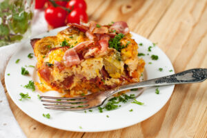 Porție de cartofi cu bacon și varză de Bruxelles pe o farfurie, cu furculiță