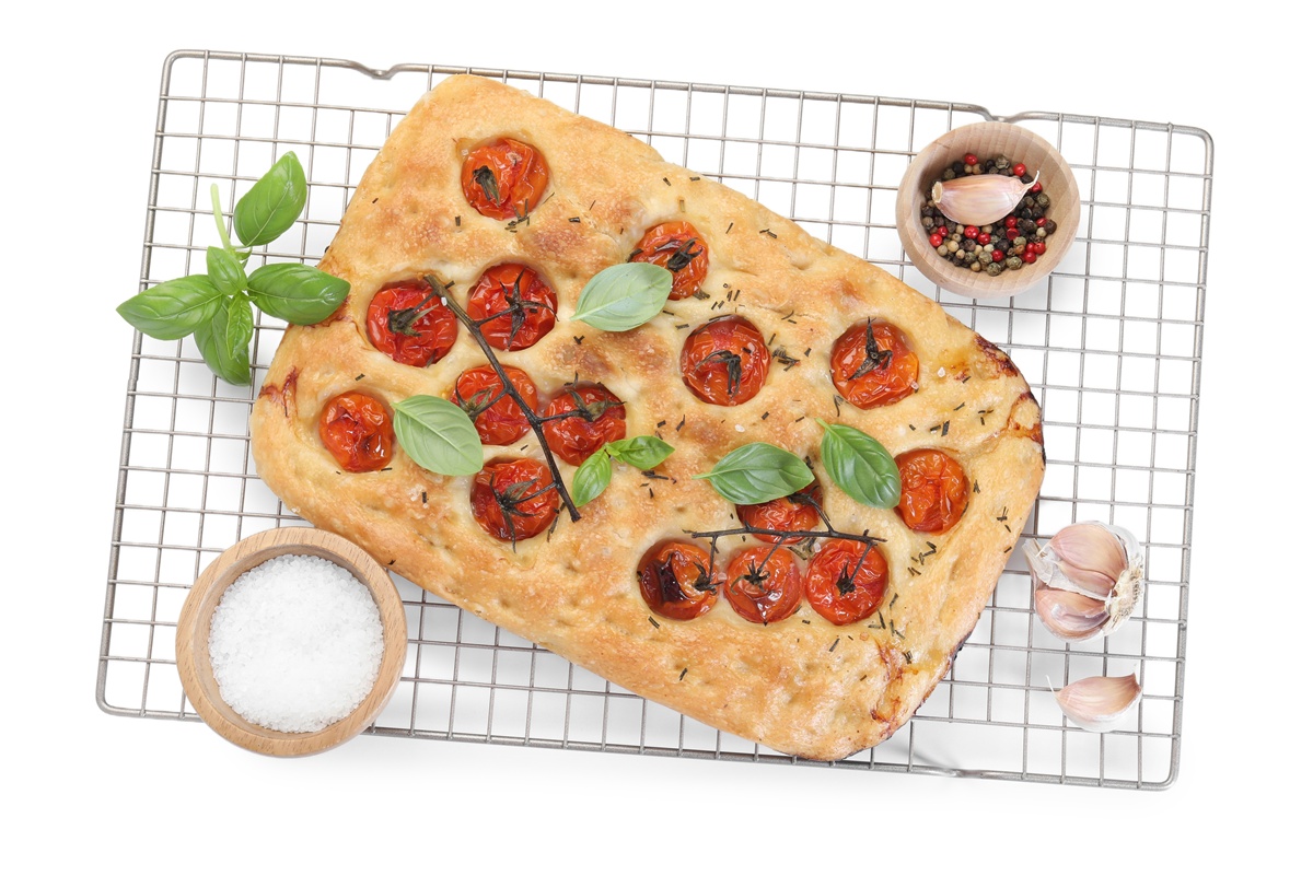 Focaccia cu roșii și frunze de busuioc pe un grătar