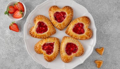 Cinci mini tarte inimioare din foietaj cu căpșuni pe o farfurie