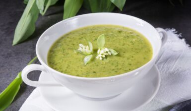 Supă cremă de leurdă în bol, decorată cu floare de leurdă