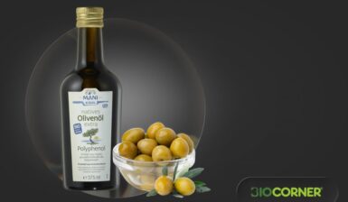 O sticlă cu ulei de măsline alături de un bol cu măsline verzi