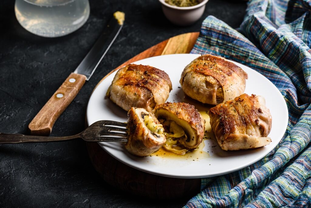 Ciuperci învelite în bacon, umplute cu brânză și usturoi