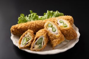 Cordon bleu cu sparanghel în interior pe o farfurie cu salată verde