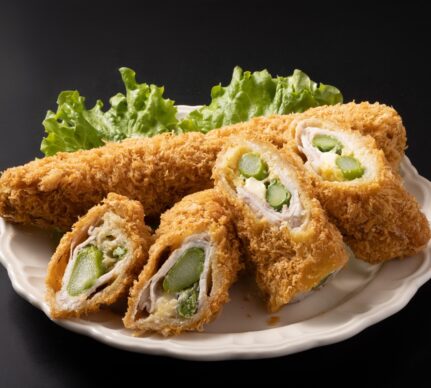 Cordon bleu cu sparanghel în interior pe o farfurie cu salată verde