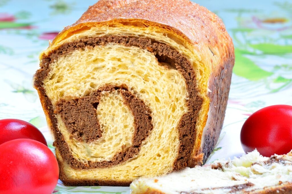 Cozonac cu halva și nuci secționat și ouă roșii