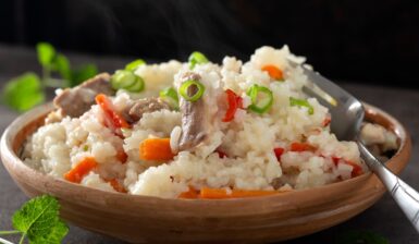 Orez cu pui și legume în bol cu furculiță