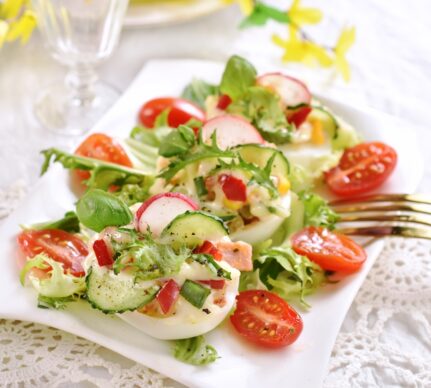 Salată cu ouă umplute și legume crocante pw un platou alb cu furculiță