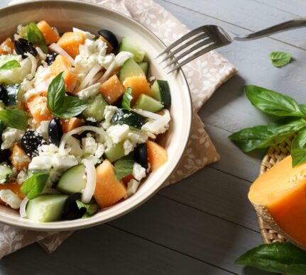 Salată cu pepene galben, castraveți și brânză feta în bol cu furculiță