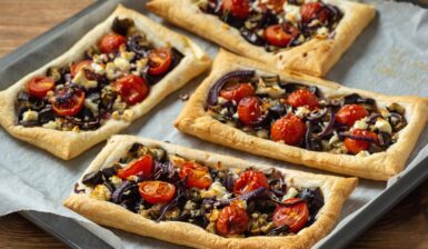 Patru tarte din foietaj cu vinete, roșii cherry, ceapă roșie și brânză feta